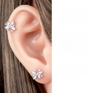 Detail of bow-shaped titanium steel ear stud set with sparkling cubic zirconia inlay
