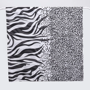 Detail of leopard and zebra print patchwork scarf hanging on a white hanger