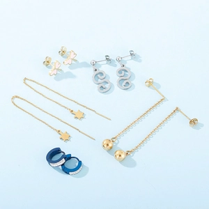 Vue à plat de plusieurs boucles d'oreilles en acier inoxydable avec pendentifs papillon