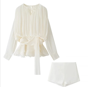 Detail of off-white satin two-piece set featuring pleated waist tie top and matching shorts