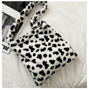 Detail of the soft cow print faux fur tote bag with a thick plush shoulder strap