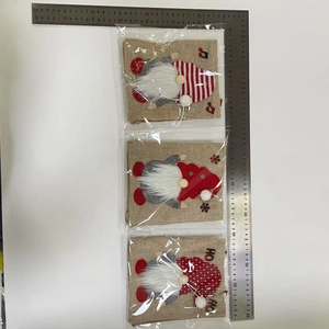Close-up of three burlap Christmas gnome gift bags with festive HO HO HO text and sequins