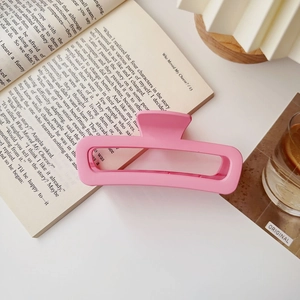 Dettaglio ravvicinato di una molletta per capelli rosa opaca su un libro aperto