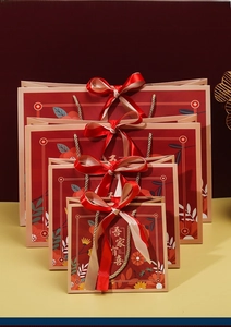 Detailed set of four red Chinese wedding gift bags with silk bows and golden lettering