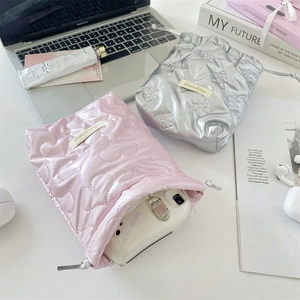 Detail showing two padded PU storage pouches with camera and fashion accessories