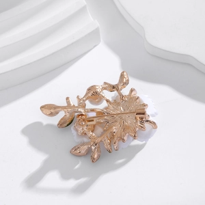 Broche marguerite dorée élégante avec pétales blancs et perle sur support en pierre