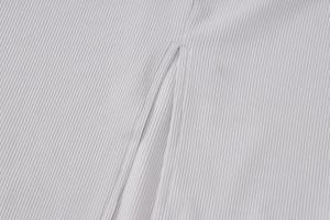 Détail d'une robe en maille côtelée grise montrant la texture et la fente de l'ourlet soignée