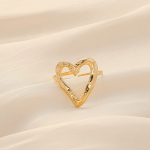 Elegant gold heart open ring with hammered texture on white silk background