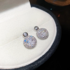 Close-up of sparkling cubic zirconia round stud earrings in a white velvet jewelry box