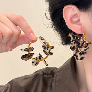 Round hoop earrings with leopard print petals and crystal beads shown on model