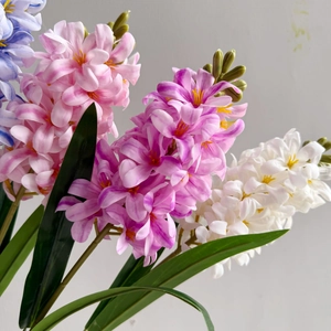 Close-up of artificial hyacinth flowers in pink and white with green leaves detail