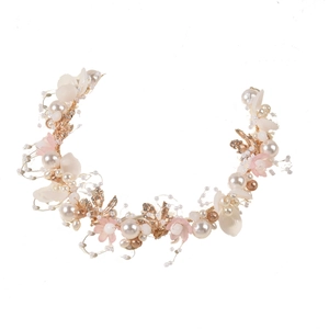 Close-up of handmade bridal headband with gold leaves, pearls, and delicate pink flowers
