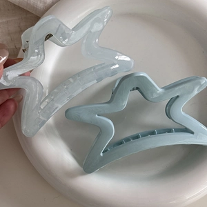 Blue and white star-shaped shark hair clips set on a minimalist background