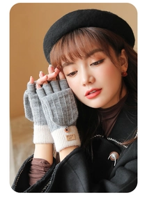 Detail of grey and beige knitted flip-top gloves with soft plush lining and buttons