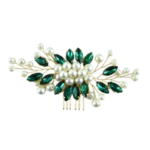 Detail of bridal hair comb featuring green marquise crystals and white pearls in gold wire