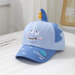 Detail of embroidered cartoon dinosaur and 3D fin on kids blue cotton baseball cap