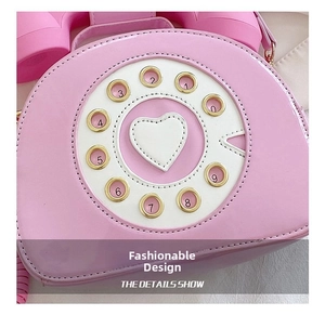 Close-up of pink retro phone bag featuring a vintage rotary dial and heart detail