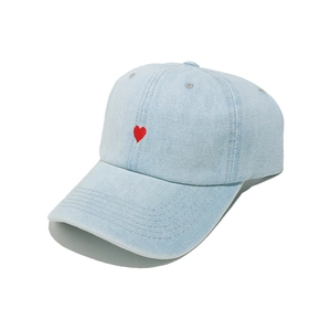 Detailed view of light blue denim baseball cap with a small red embroidered heart