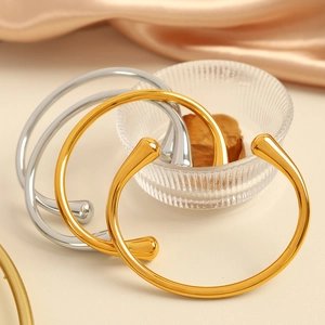 Bracciali aperti in acciaio al titanio lucido color oro e argento su seta pregiata