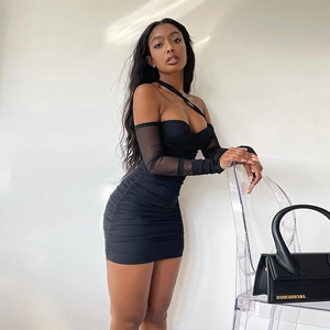 Détails des manches en résille et tissu plissé sur robe moulante noire bustier
