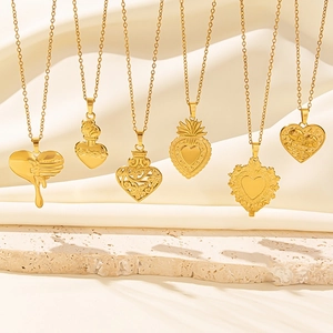 Six assorted heart-shaped 18k gold plated stainless steel necklaces on stone pedestal