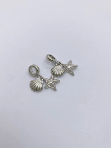 Macro shot of silver seashell and starfish charm pendant with micro-inlaid zirconia