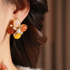 Détail de la boucle d'oreille vintage avec perle centrale et pierres précieuses colorées