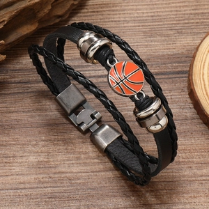 Detail of multi-layer woven leather bracelet featuring a vintage orange basketball charm