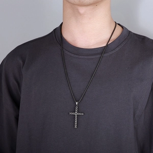 Close-up of vintage stainless steel cross pendant with detailed wheat pattern on chain