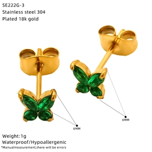 Macro detail of 6mm golden butterfly studs with green marquise zircon and 18K plating