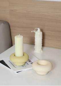 Detailed close-up of modern ceramic donut candle holders in olive green and beige colors