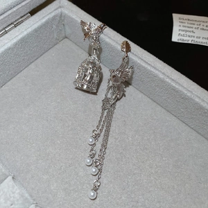 Detail von asymmetrischen Vogel-Ohrringen in Silber mit Perlen und Quastenketten