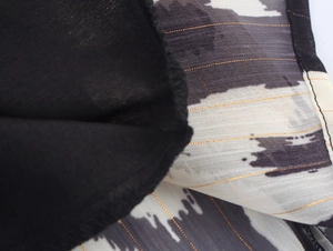 Detail of black and white printed chiffon fabric with shimmering gold metallic threads