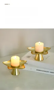 Detail of Nordic golden star candle holders with handcrafted hammered texture and matte finish