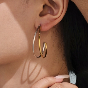 Boucles d'oreilles classiques en C bicolores or et argent portées par un mannequin