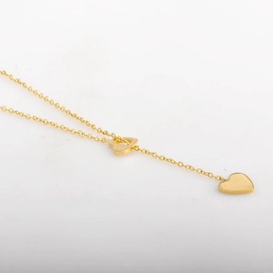 Collana minimalista dorata con ciondoli a cuore cavo e pieno su una sottile catena d'oro