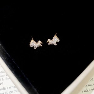 Macro shot of gold plated pony stud earrings with crystals on black velvet
