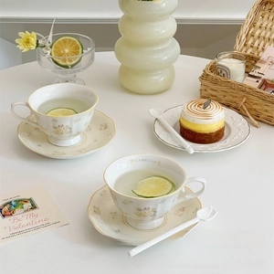 Detail view of white ceramic tea set with camellia patterns and elegant gold edges