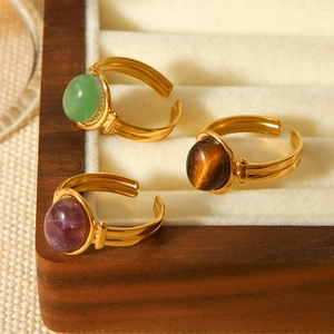 Detail of three 18K gold plated stainless steel rings with colorful semi-precious stones