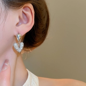 Boucles d'oreilles cœur goutte en zircon argenté portées par un mannequin élégant