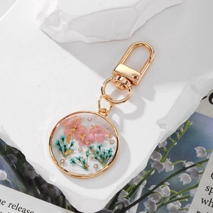 Handmade resin keychain with real dried flowers and gold foil in round golden frame