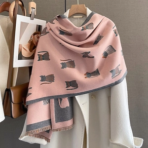 Detailed view of pink cashmere-texture scarf with grey cat patterns and tassel edges