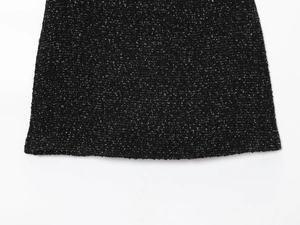 Gros plan sur la texture du tissu en tweed noir et les détails de l'ourlet pour femmes