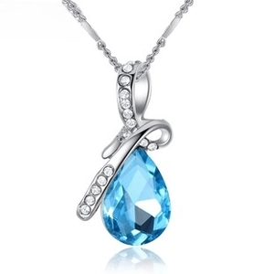 Macro shot of silver water drop necklace with ocean blue crystal and pavé zircon details
