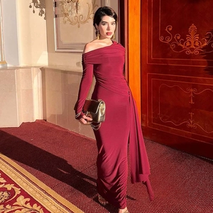 Detail view of the elegant burgundy one-shoulder dress with pleated texture and side slit