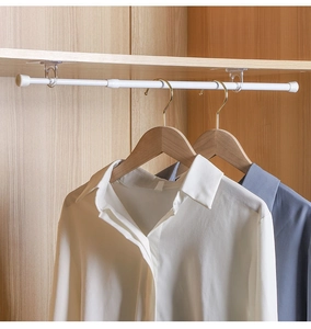 Adjustable white metal closet tension rod with transparent adhesive hooks on wood panel