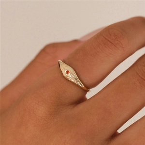 Macro shot of gold S925 ring featuring engraved star motifs and orange gemstone