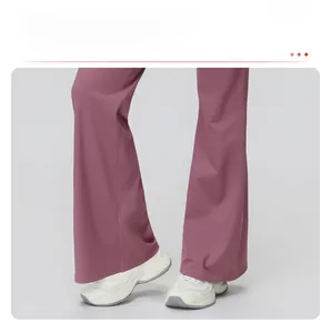 Gros plan d'un pantalon de sport large violet fumé montrant le drapé fluide de la matière