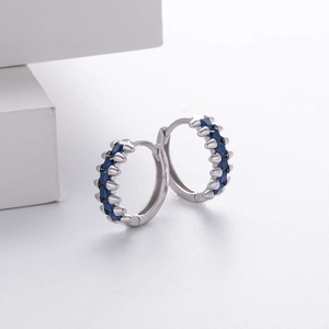 Macro detail of silver S925 earrings featuring square-cut deep blue zircon stones