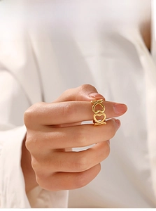 Detail of minimalist open ring featuring two interconnected golden hollow hearts